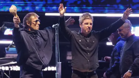 Reuters Liam and Noel Gallagher of Oasis with their arms outstretched accepting applause from the audience at the Rose Bowl Stadium in Pasadena, California in September 2025