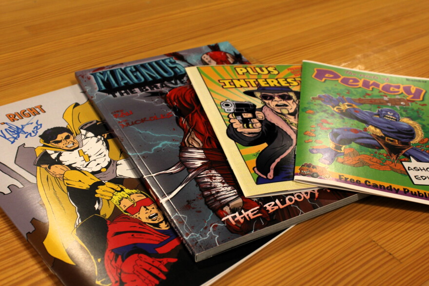 A stack of comics under the Free Candy Publishing brand. Left to right: "Mr. Right" (by Kim Cotterell), "Magnus the Brave" (by Ace Nuckolls and Chris Rau), and two "ashcan" demos of upcoming issues: "Plus Interest" and "The Trials of Percy."