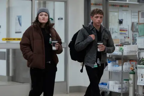 Warner Brothers Picture of two medical staff holding coffees