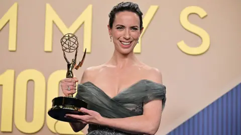 Getty Images Kate O'Flynn holds up her Emmy Awards statue backstage after accepting the prize for supporting actor in a comedy series