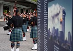 A display shows name after name of Sept. 11, 2001 attacks victims listed surrounding an image of the World Trade Center’s South Tower on fire, as Portland Fire Fighters Pipes and Drums performs to start a ceremony to commemorate the 9/11 terrorist attacks, at Waterfront Park in Portland, Ore., on Sept. 11, 2026.