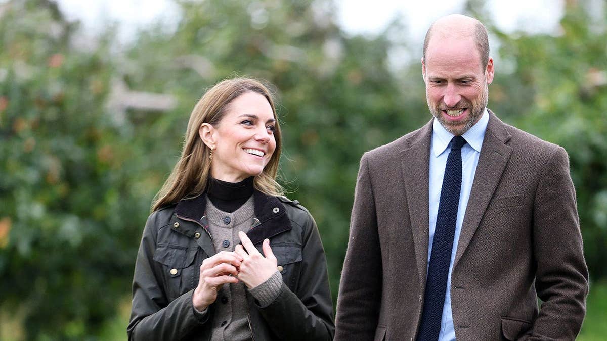 Kate Middleton looking adoringly at Prince William while walking outdoors.