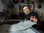 Philip R. Simon shows art boards from "Age of Reptiles" by Ricardo Delgado at the company headquarters in May. The artist still hand-draws his comics, which is increasingly rare now that most art boards are digitized.