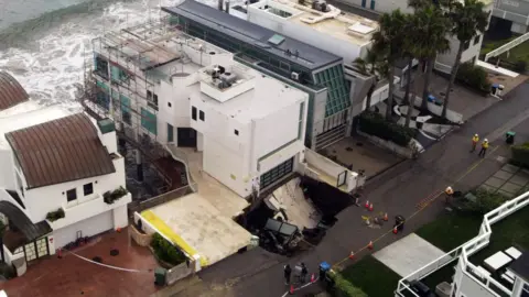 Getty Images This aerial view shows a sinkhole on a street and driveway of a seaside home affected by large swells produced by Hurricane Marie in Malibu, California, on September 8, 2026. Hurricane Marie stayed well offshore of Southern California during Labor Day weekend but its large swells produced dangerous surf and rip currents, with waves reaching around 10 feet in some areas.