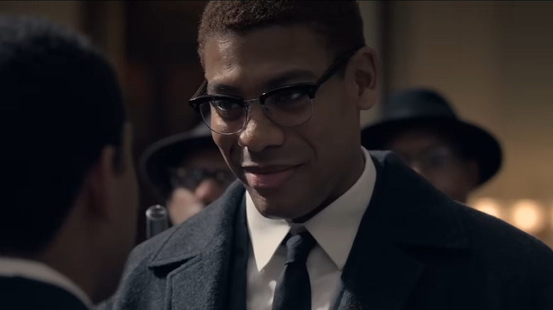 Aaron Pierre wearing glasses and smiling in Genius