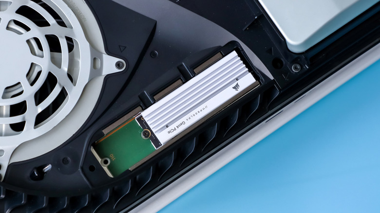 An open PlayStation 5 console showing the expanded storage SSD slot with an SSD