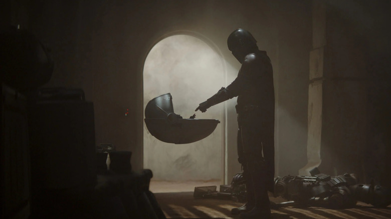 Din Djarin reaches out to Grogu in The Mandalorian.