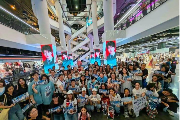 Members of Yang Yang’s fan club pose for a birthday celebration photo in front of LED screens on towering pillars at Union Mall in Bangkok. Captured from Yang Yang’s Thai fan page
