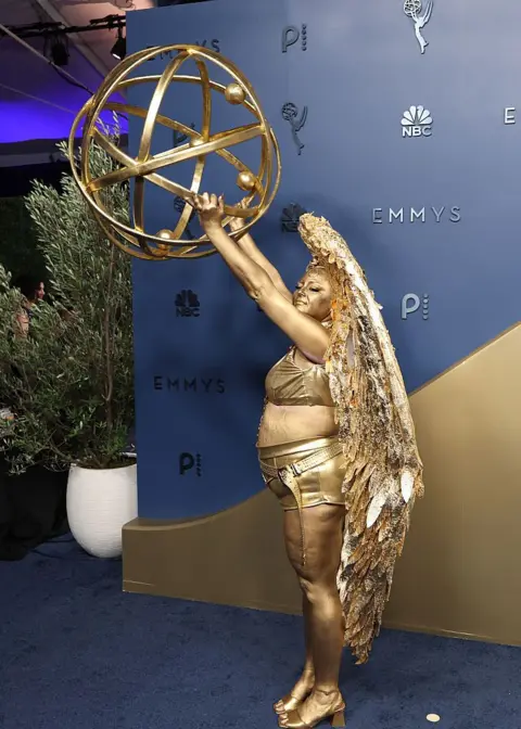 Getty Images Megan Stalter dresses as an Emmy Awards statue on the blue carpet at the 78th Emmy Awards held at Peacock Theater on September 14, 2026 in Los Angeles, California.
