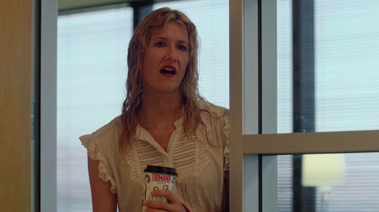Amy standing at an office entryway and holding a coffee cup on Enlightened S1E5