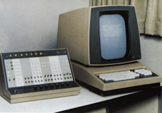 A vintage desktop computer from the 1970s with a small, narrow screen and a keyboard attached to it.