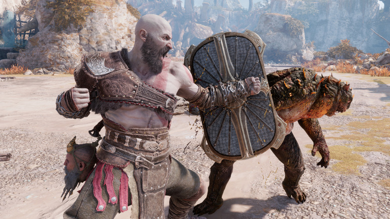 Kratos prepares to punch a scaly monster in God of War Ragnarök