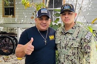 In this photo courtesy of Katherine Delgado shows her step-father Luis Manuel Aviles, left, and her brother Joshua Aviles stand outside their home in Oct. 2025, shortly before Joshua deployed on the USS Lincoln the following month in Key West, Florida.