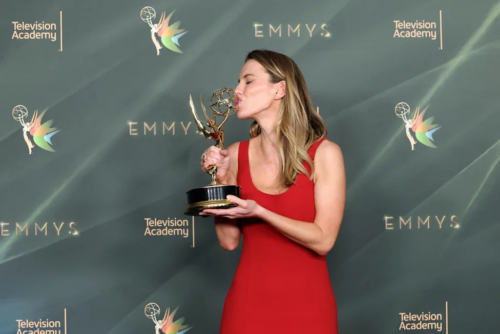 Betty Gilpin kisses her Emmy.