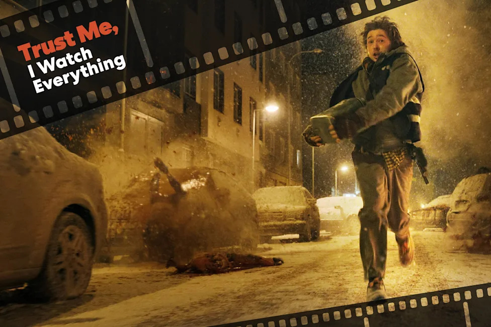 Austin Abrams in Resident Evil. Person runs through a snowy street amid an explosion, with filmstrip graphics and text reading "Trust Me, I Watch Everything"