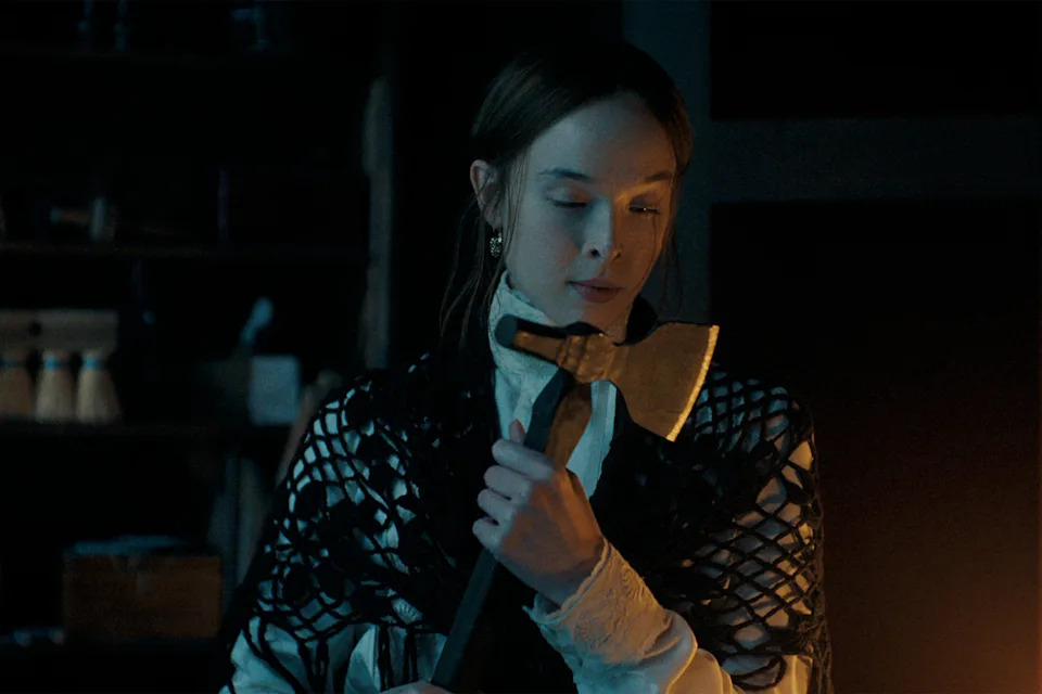 Ella Beatty holding an axe in a scene from Netflix's Monster: The Lizzie Borden Story