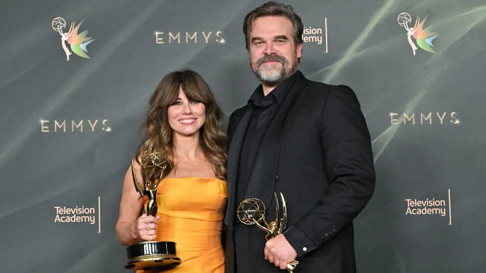 US actress Linda Cardellini, wearing an orange dress, and US actor David Harbour, in a black suit, pose with their Emmys for outstanding supporting actress and actor in a limited or anthology series or movie for DTF St. Louis.