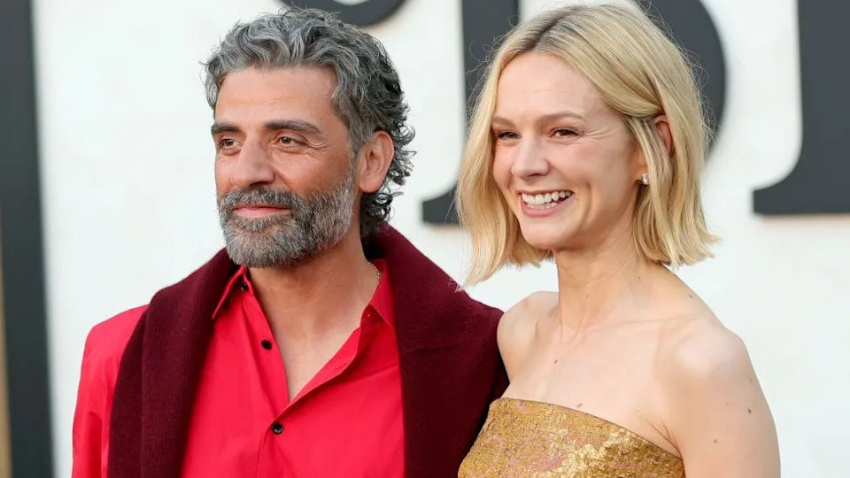 Oscar Isaac, wearing a red shirt, and Carey Mulligan, waring a gold sequinned dress, attend the Los Angeles premiere of Netflix's Beef season two in Los Angeles
