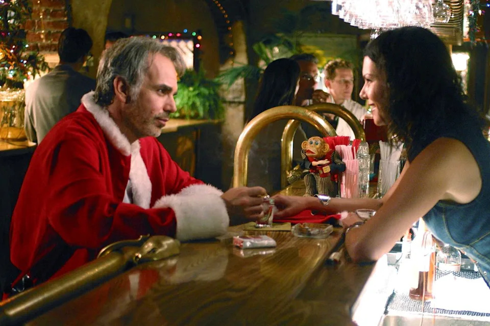 Billy Bob Thornton in a Santa costume talking to Lauren Graham at a bar in 'Bad Santa'Credit: Everett