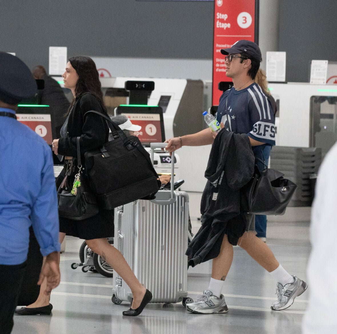 Hudson Williams and Katelyn Larson walking together in Toronto Airport