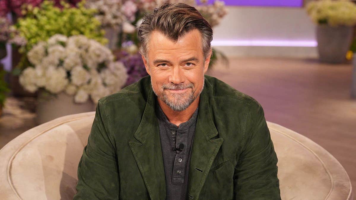 Josh Duhamel seated on a talk show set in Burbank, California.