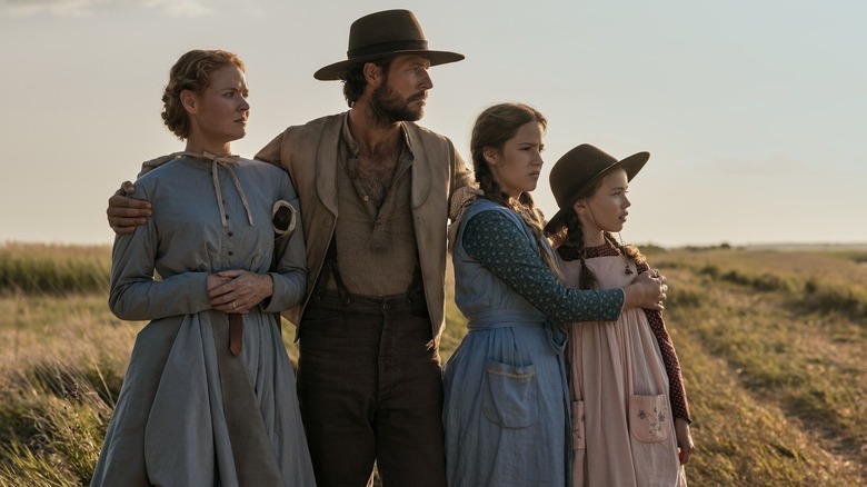 Caroline (Crosby Fitzgerald), Charles (Luke Bracey), Mary (Skywalker Hughes), and Laura (Alice Halsey) standing together on "Little House on the Prairie."