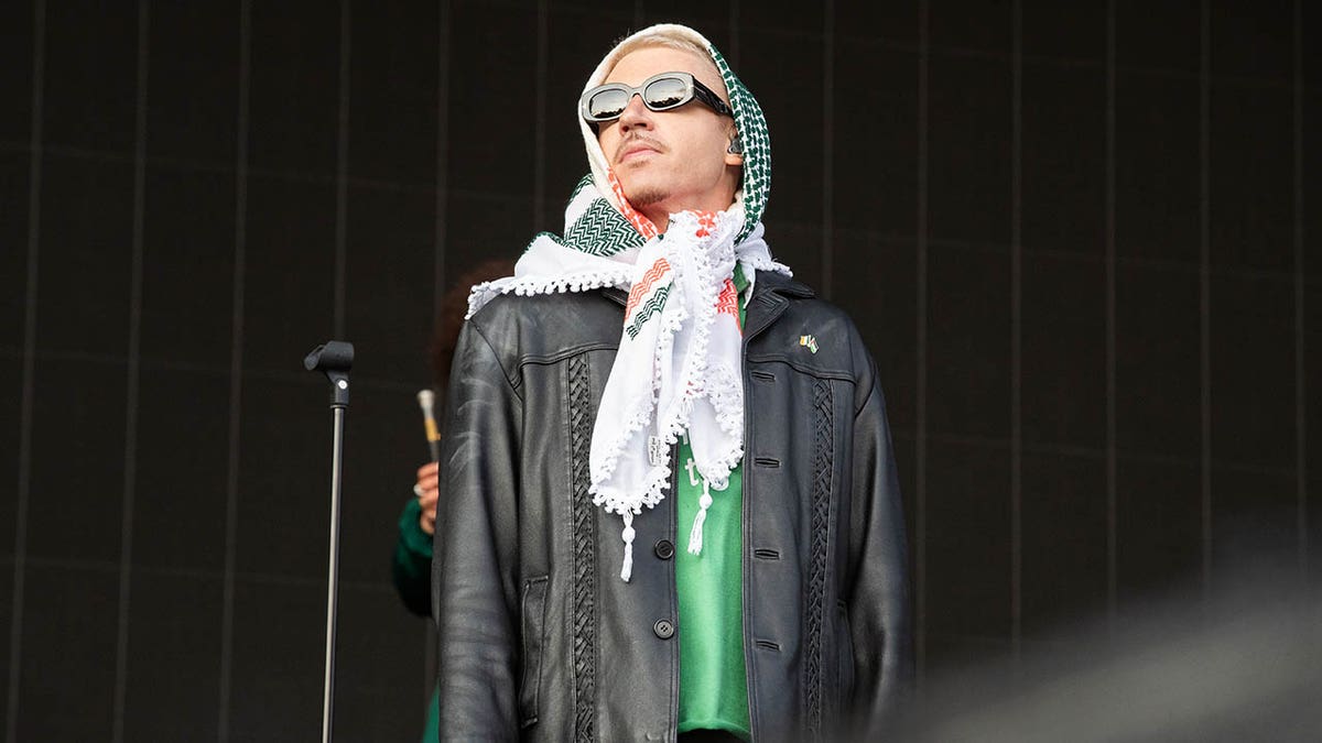 Macklemore stands onstage during a concert