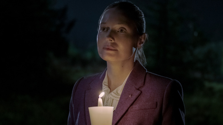 Bev Keane holding a candle outside