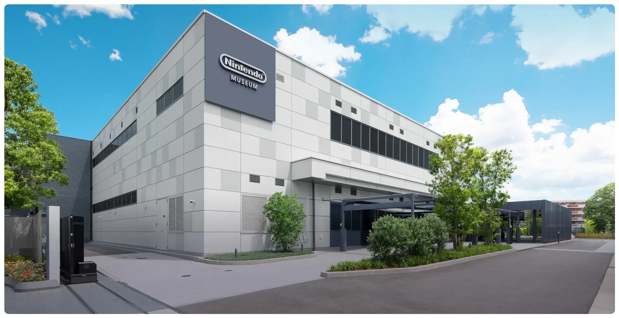 The exterior of the Nintendo Museum in Kyoto, a low grey and white building with the museum's logo on its facade.