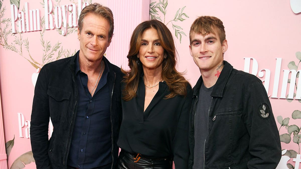 Rande Gerber pictured with Cindy Crawford and their son Presley on a red carpet