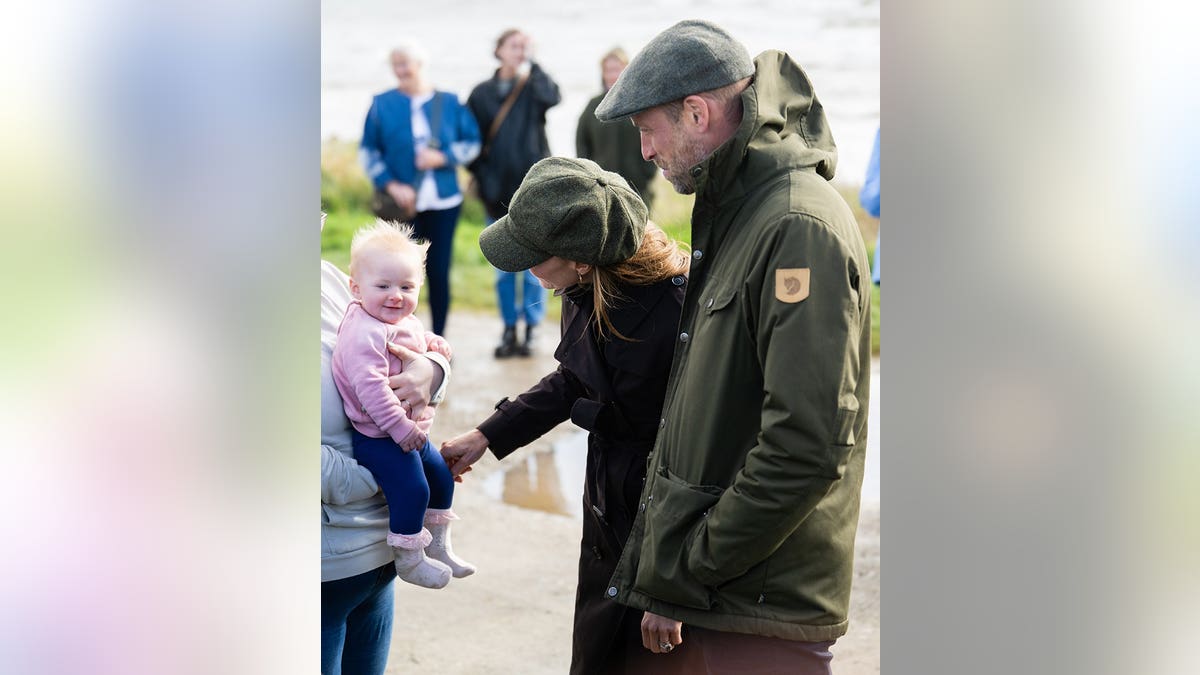 Prince William, Prince of Wales, and Catherine, Princess of Wales, stand outdoors at Ettrick Bay.