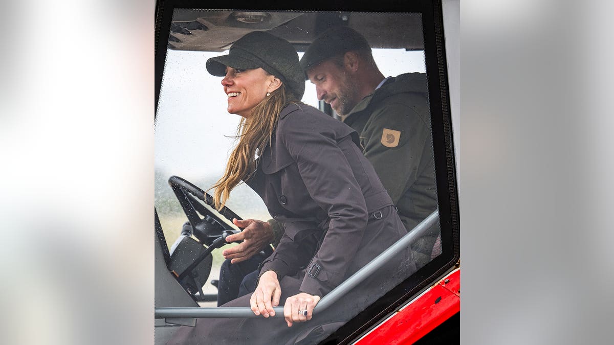 Prince William and Catherine, Princess of Wales, drive a tractor at Ettrick Bay during clean-up activities.