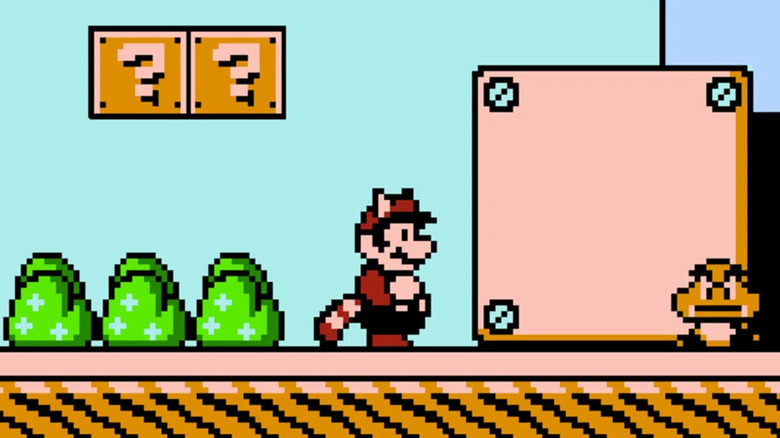 Mario in the Tanooki suit watches an incoming Goomba in Super Mario Bros. 3