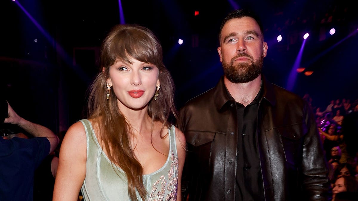 Taylor Swift and Travis Kelce standing together at the Dolby Theatre in Los Angeles