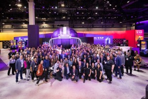 Group of attendees walking through G2E with branded booths and activations in the background
