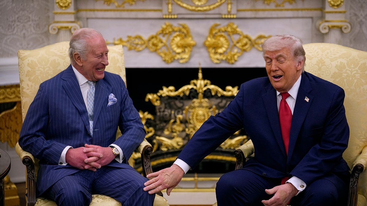 President Donald Trump touches King Charles III in the Oval Office.