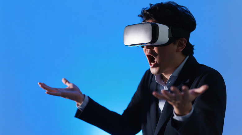 A man wearing a VR headset looks amazed.