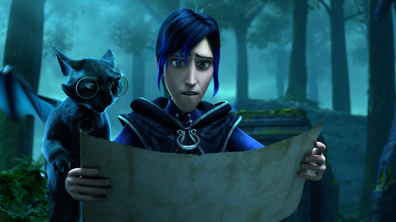 Douxie looking at a map sadly with Archie peering over his shoulder in a dark forest in Wizards