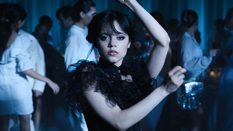 Jenna Ortega as Wednesday Addams, dancing at a party in Wednesday.