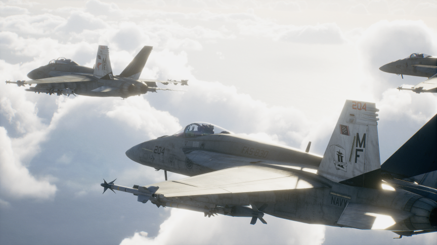 An other-the-shoulder look at three F-18E jets flying in close formation above the clouds.