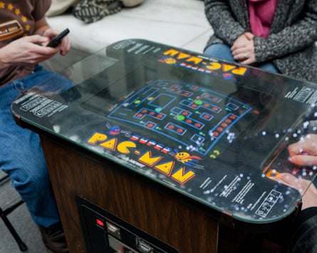 People playing a vintage Pac-Man video arcade game.