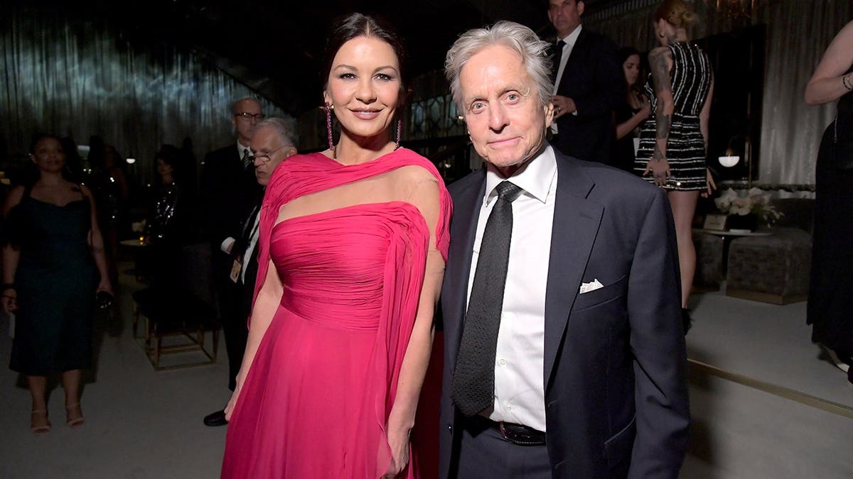 Catherine Zeta-Jones and Michael Douglas stand together at an event.