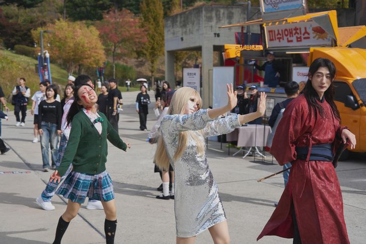 Fans dressed in costumes inspired by characters from Netflix Korean series pose for photos during the Netflix Janchi fan event at Oil Tank Culture Park in Mapo District, western Seoul, Sunday. Courtesy of Netflix