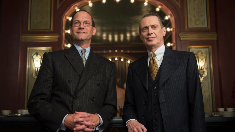 Matt Letscher and Steve Buscemi as Joseph Kennedy and Nucky Thompson, standing together in a club in Boardwalk Empire.