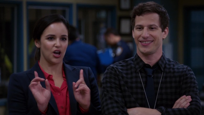 Melissa Fumero and Andy Samberg as Amy and Jake standing together in Brooklyn Nine-Nine