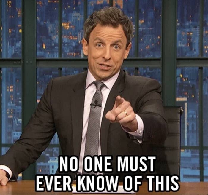 TV host in a suit points forward with a humorous expression. Text overlay: "No one must ever know of this."