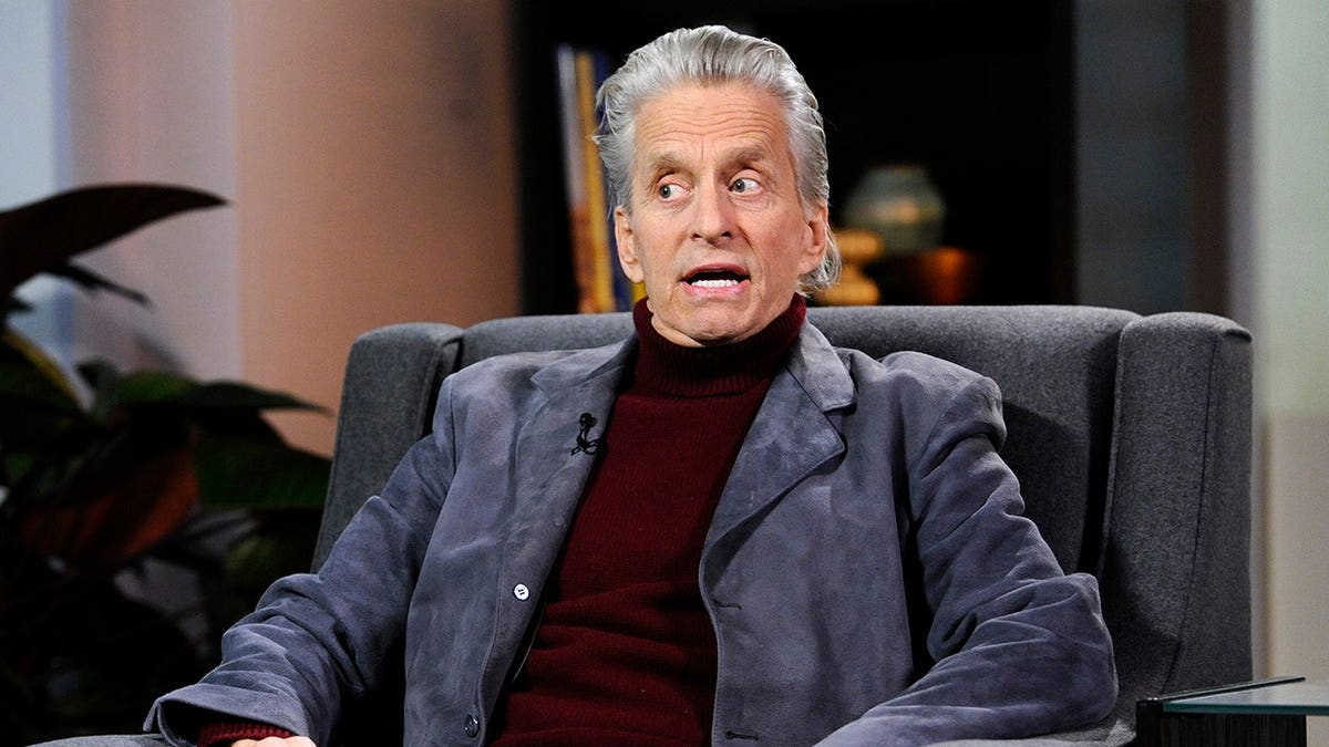 Michael Douglas sits during a television interview.