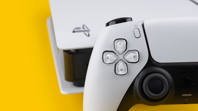 A close-up shot of the PS5 and its DualSense controller against a yellow background.