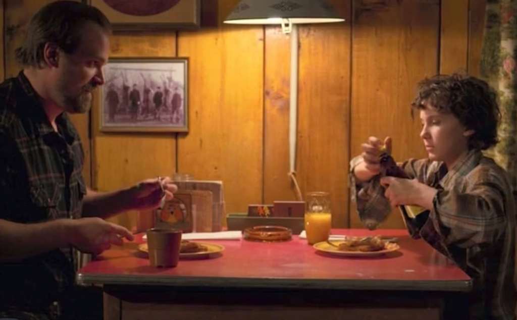 Eleven and Hopper having breakfast in a still from Stranger Things.