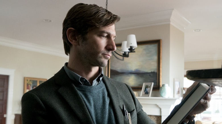 Steven Crain examines the front of a book in "The Haunting of Hill House."